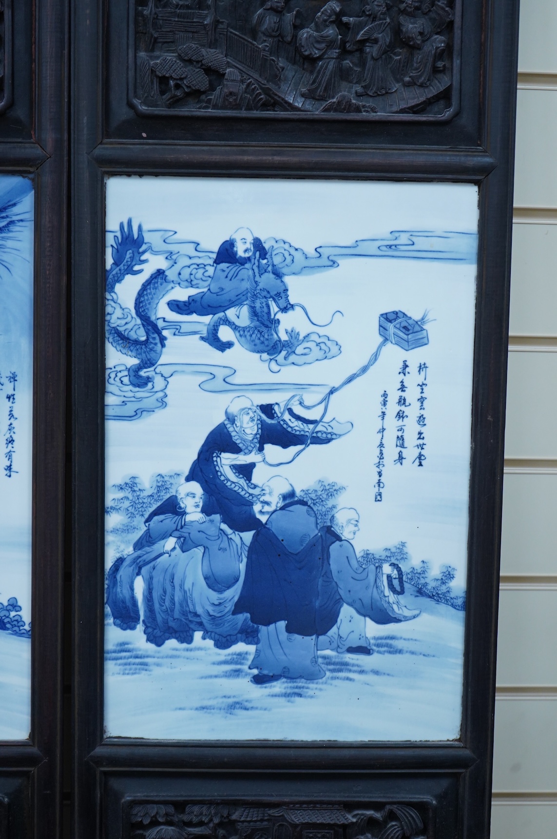 A pair of Chinese blue and white porcelain plaques, inset carved wood frames, 84cm x 32cm